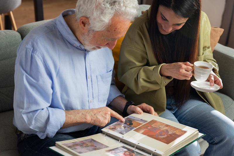 old man showing photo album to a woman